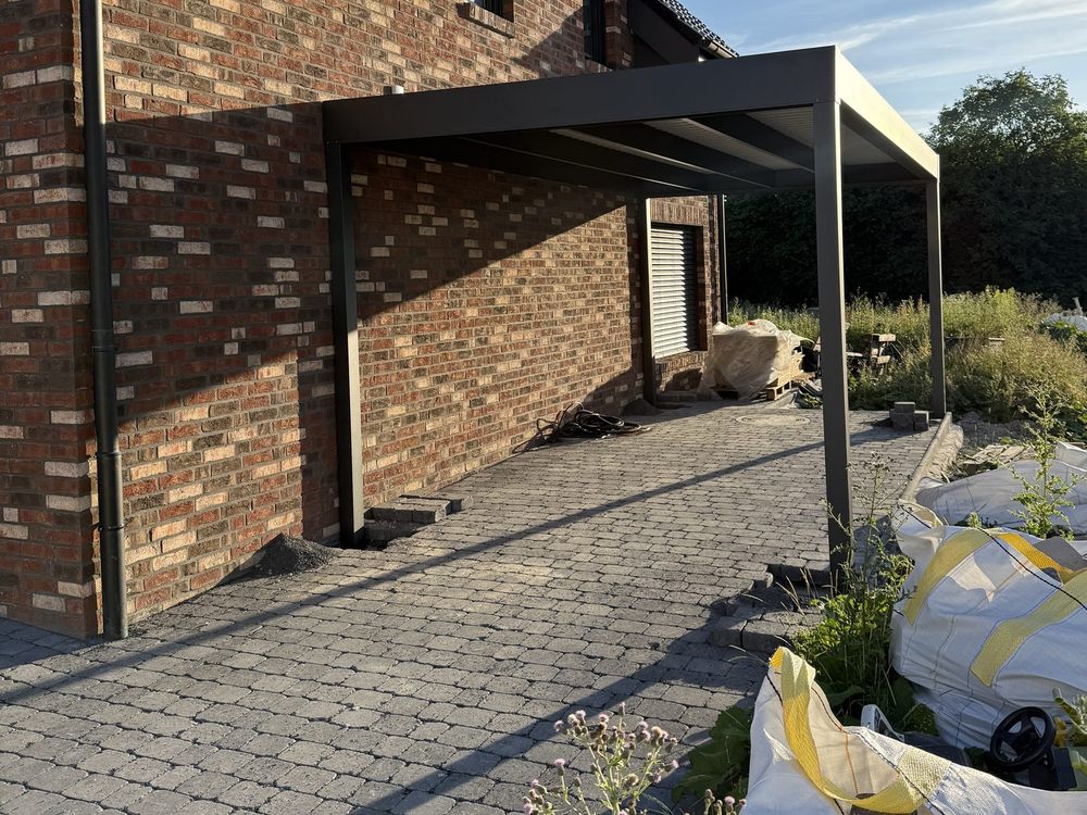 Seitlicher Carport am Klinkerhaus mit Pflasterfläche